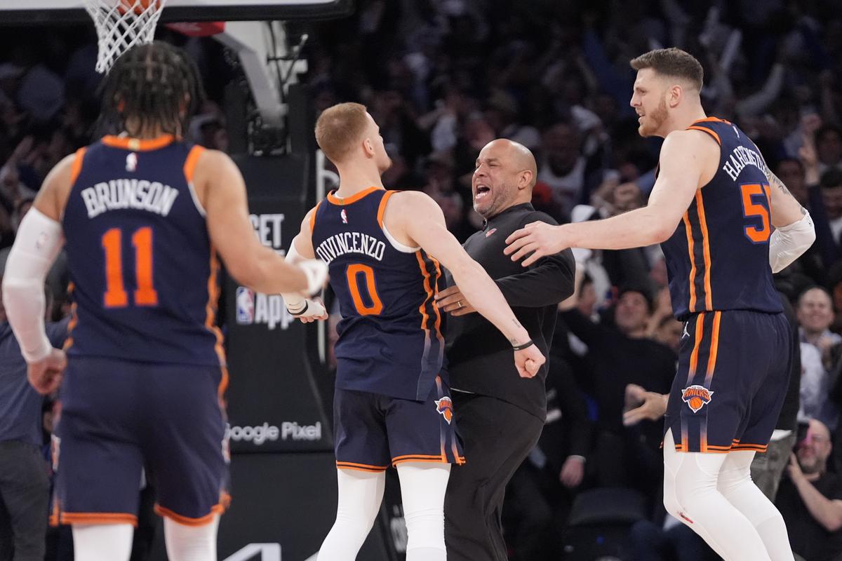 New York Knicks’ Donte DiVincenzo (0) celebrates with teammates after hitting a 3-point basket against Philadelphia 76ers.