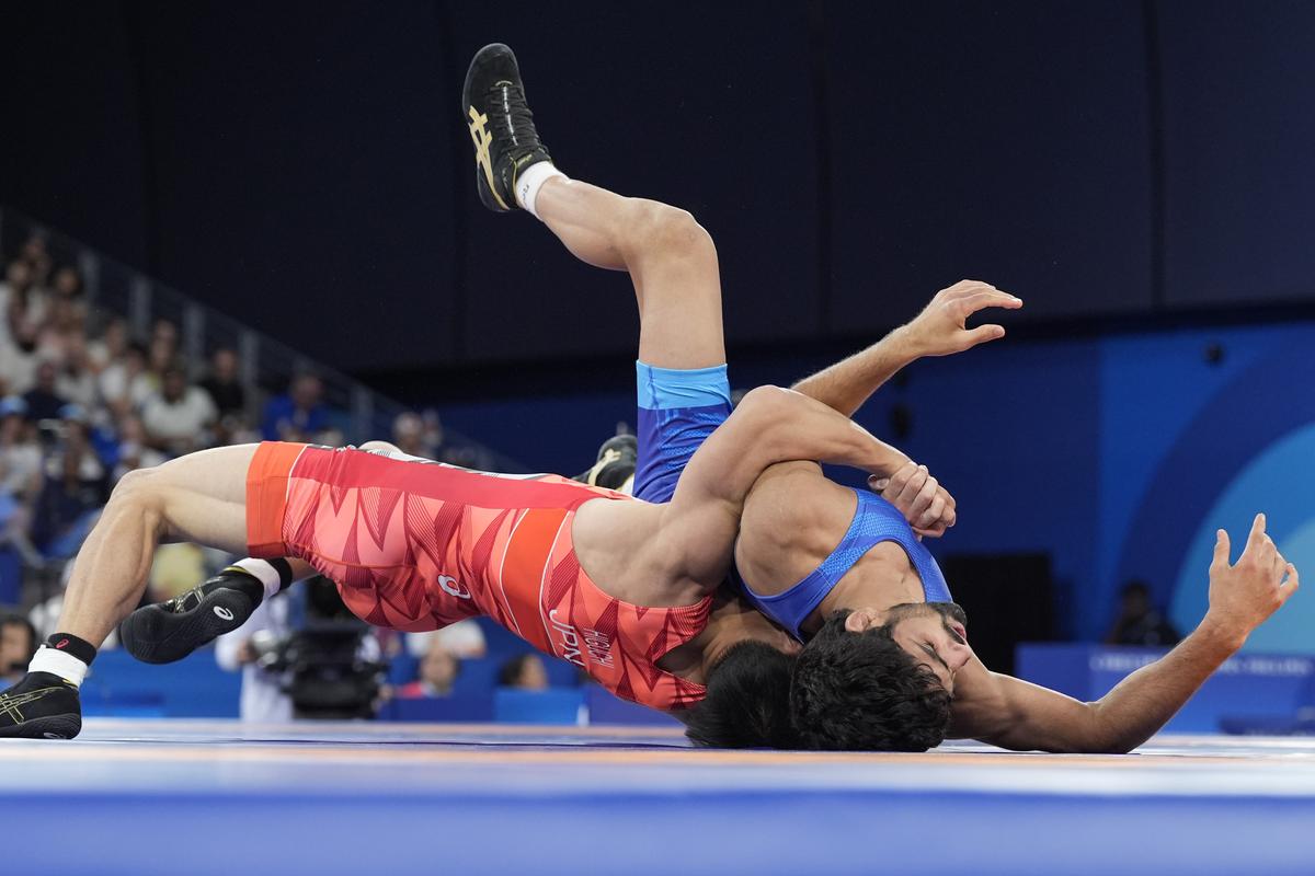 Japan’s Rei Higuchi and India’s Aman compete in their men’s freestyle 57kg semifinal wrestling match. 