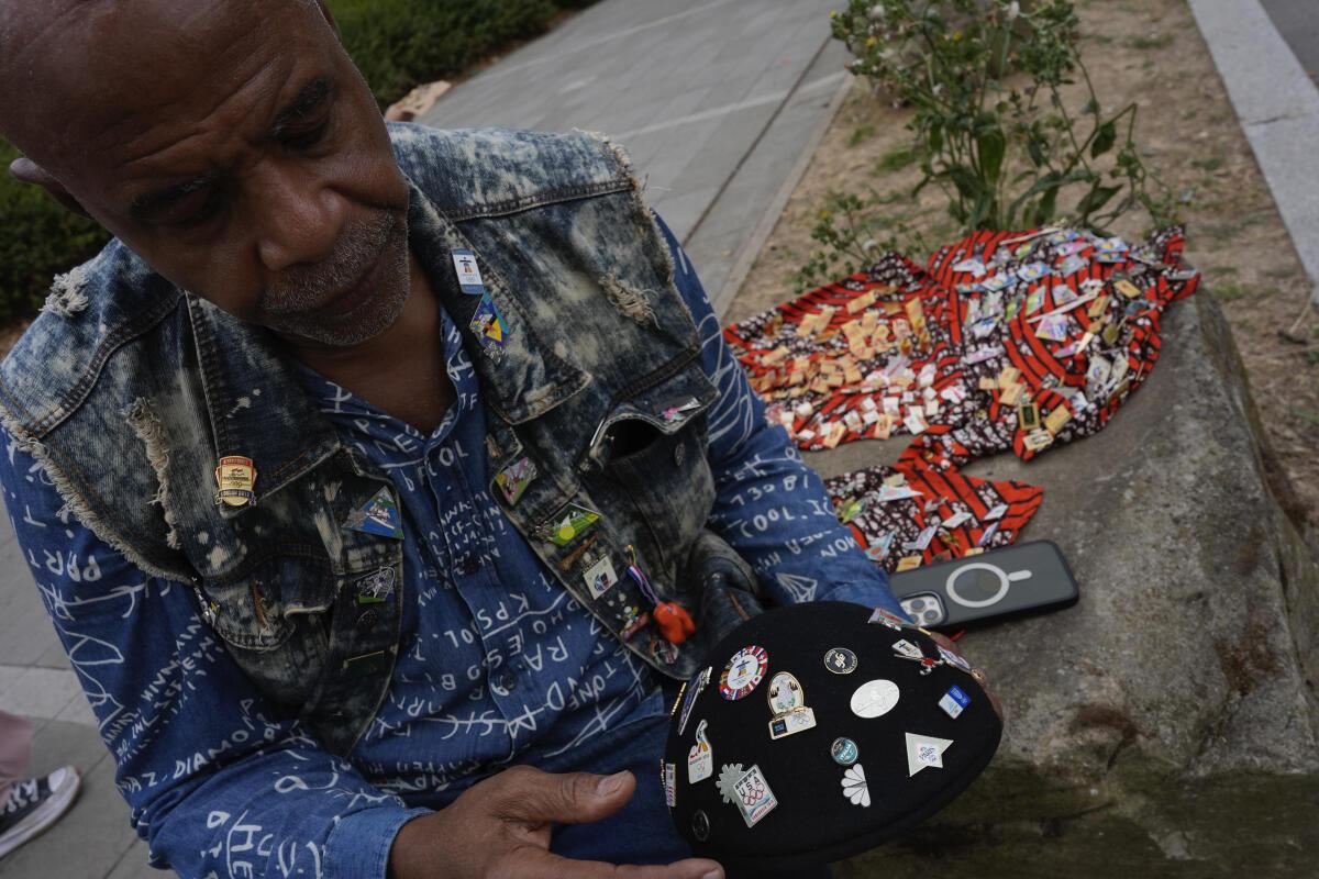 Thurston Bilal of Los Angeles waits outside the Olympic Village to trade Olympic pins with athletes and other collectors. 