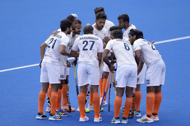 Indian players gather around Harmanpreet Singh after he scored his side’s third goal against Wales on Thursday. 