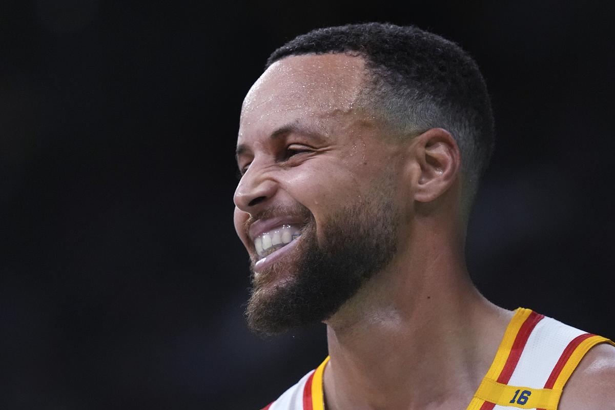 Golden State Warriors guard Stephen Curry smiles during the second half of an NBA basketball game against the Boston Celtics.