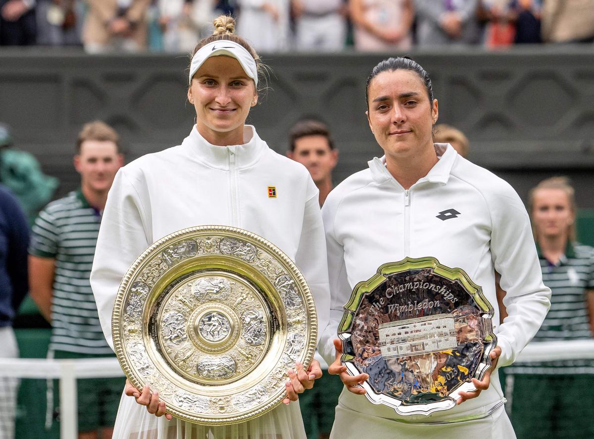 Marketa Vondrousova (L) and Ons Jabeur (R) with their respective Wimbledon trophies after the final. 