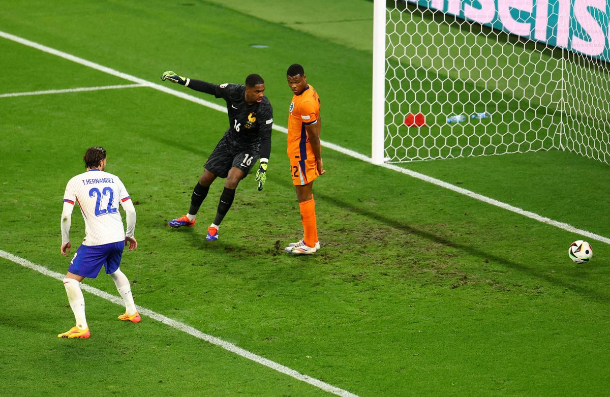 France’s Mike Maignan and Netherlands’ Denzel Dumfries look on as Netherlands’ Xavi Simons scores their first goal before it is disallowed after a VAR review. 