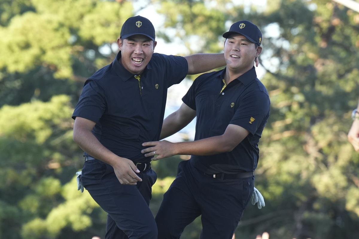 International team member Si Woo Kim of South Korea, celebrates with team member Byeong Hun An of South Korea, after sinking the winning putt on the 18th hole during second round foursome match at the Presidents Cup Golf Tournament.