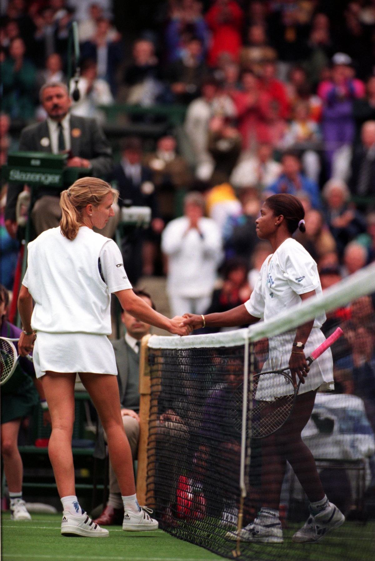 Germany’s Steffi Graf (left) shakes hands with USA’s Lori McNeil (right) after losing *in first round of Wimbledon on June 21, 1994.