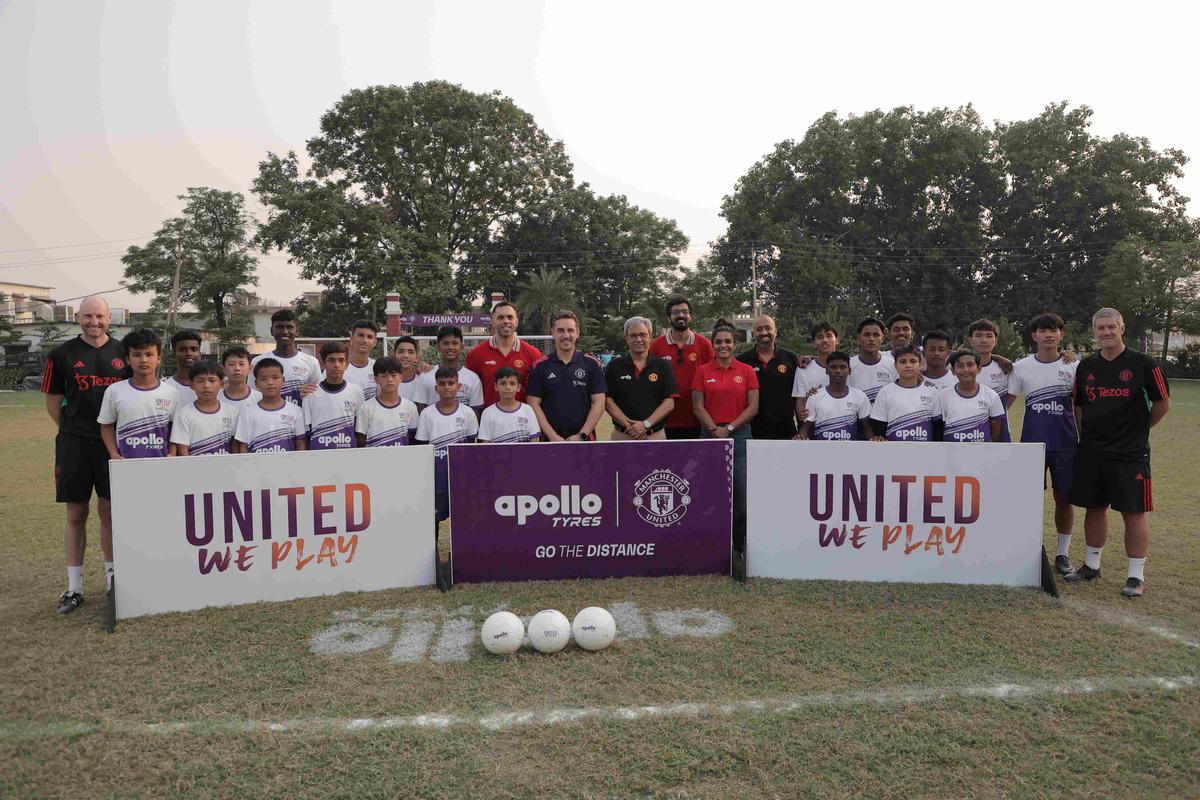 Gary Neville (centro) posa con todo el equipo de United We Play en la Academia Minerva mientras ven a cinco jugadores seleccionados de un grupo de 15.000.