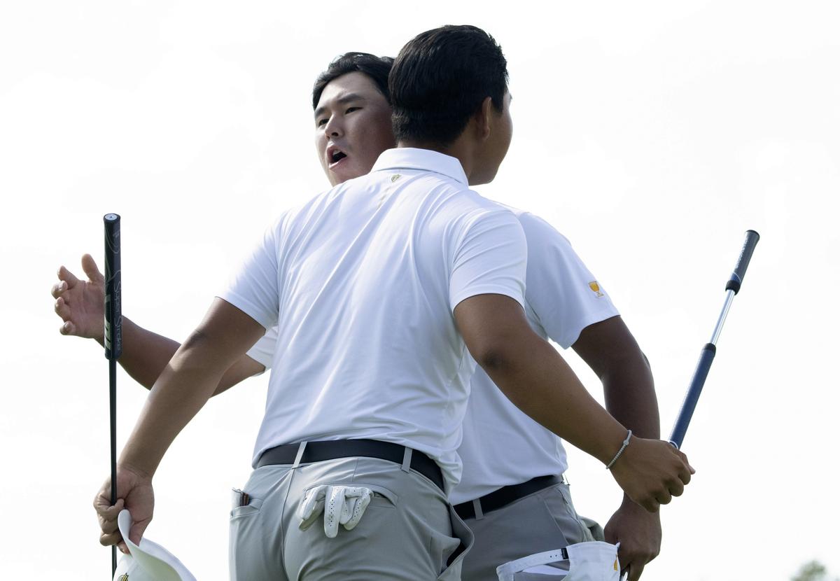 International team member Si Woo Kim, rear, of South Korea, celebrates with partner Tom Kim, of South Korea, after winning on the 15th hole during the third round at the Presidents Cup.