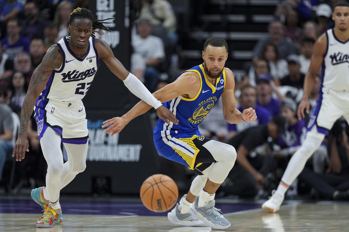 Sacramento Kings guard Keon Ellis (L) and Golden State Warriors guard Stephen Curry chase after a loose ball.