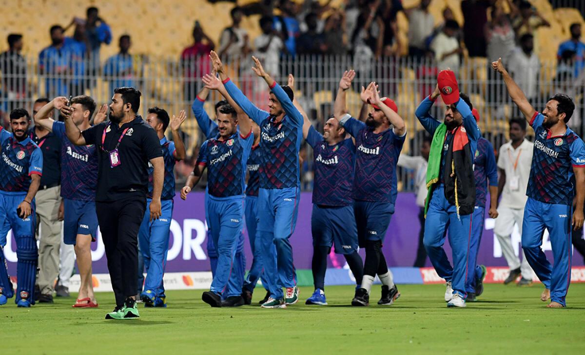 Members of the Afghan cricket team taking a victory lap at the MA Chidambaram Stadium in Chennai after beating Pakistan for the first time in the format