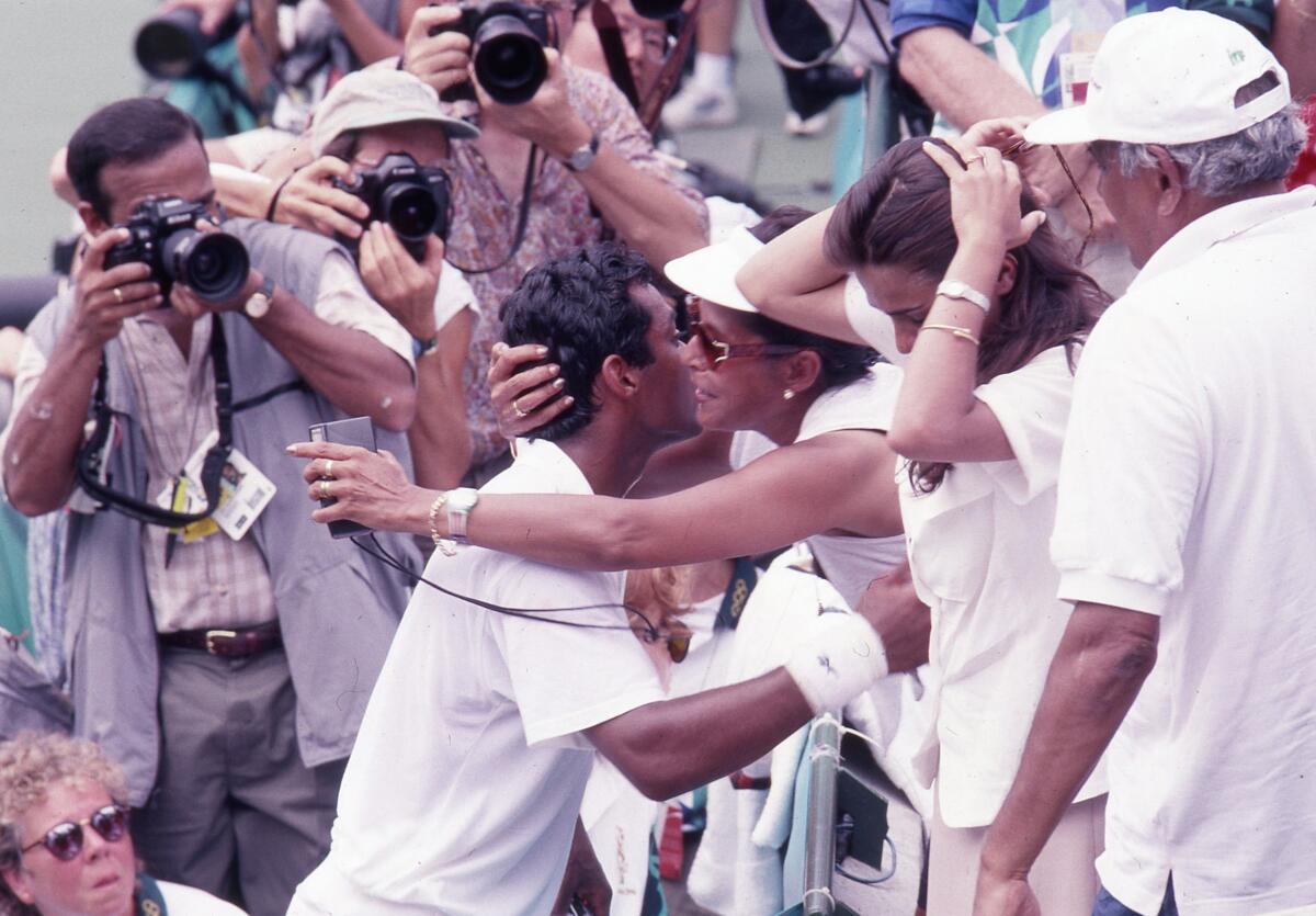 India’s Leander Paes gets a kiss from his mother Jennifer as photographers take snaps after Leander Paes beat Fernando Meligeni of Brazil to win the bronze medal at the Atlanta Olympics on August 3, 1996.  
