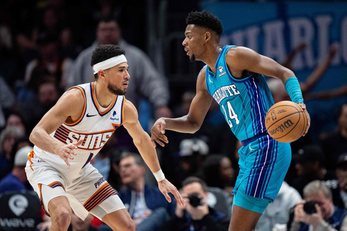 Devin Booker #1 of the Phoenix Suns guards Brandon Miller #24 of the Charlotte Hornets in the fourth quarter during their game at Spectrum Center on March 15, 2024 in Charlotte, North Carolina.