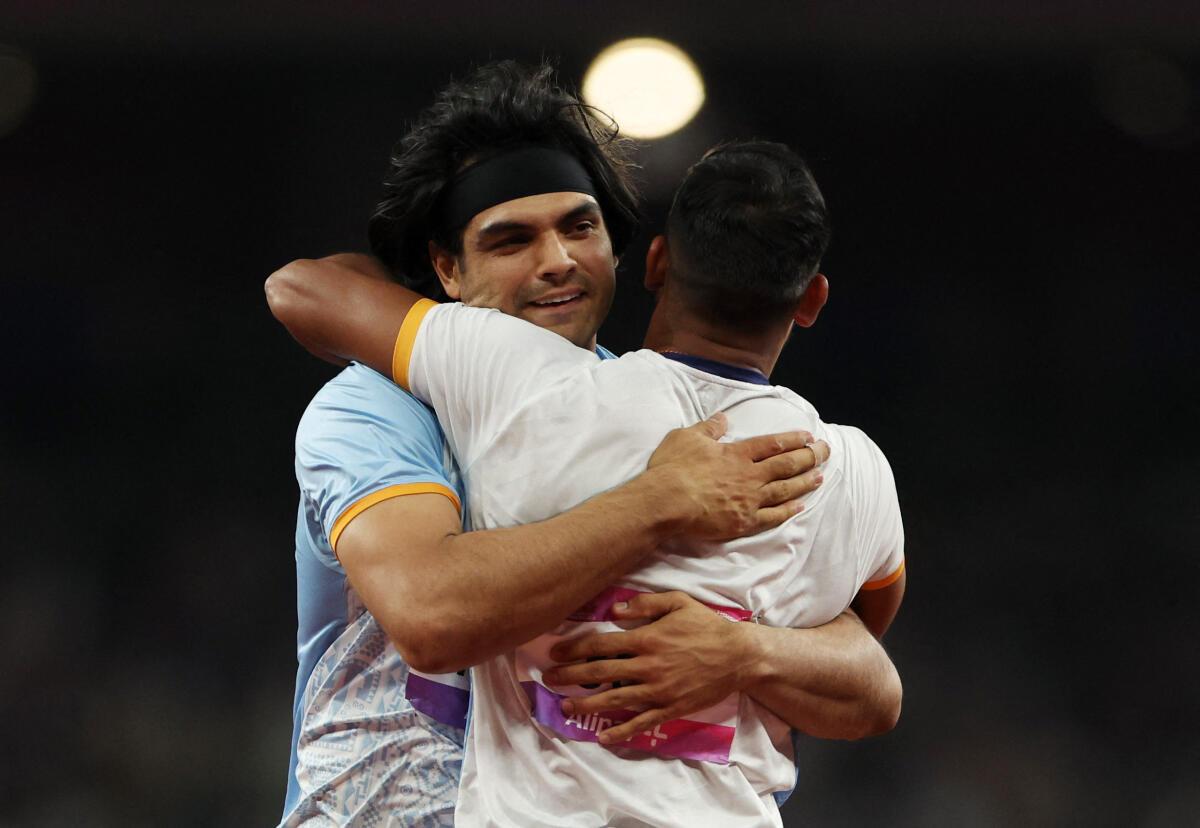 A bear hug: Neeraj Chopra joins the celebration after Kishore Kumar Jena’s mammoth throw.