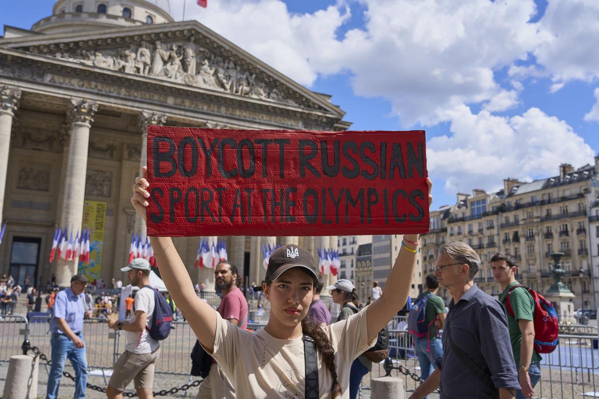 A woman holds a sign with the text “Boycott Russian sport at the Olympics” during a march in memory of the hundreds of Ukrainian athletes killed since the Russian invasion of the Ukraine on July 13, 2024 in Paris, France.