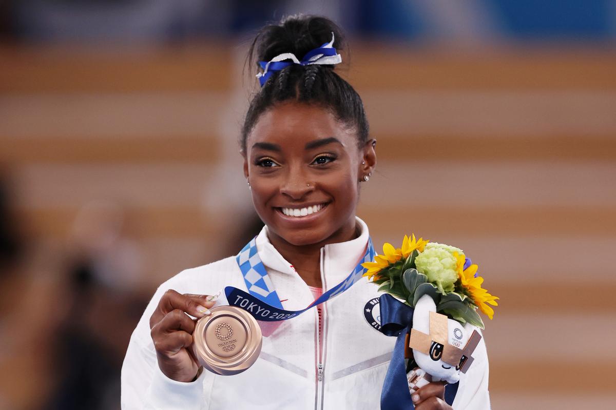 Simone Biles poses with the bronze medal during the Women’s Balance Beam Final medal ceremony.