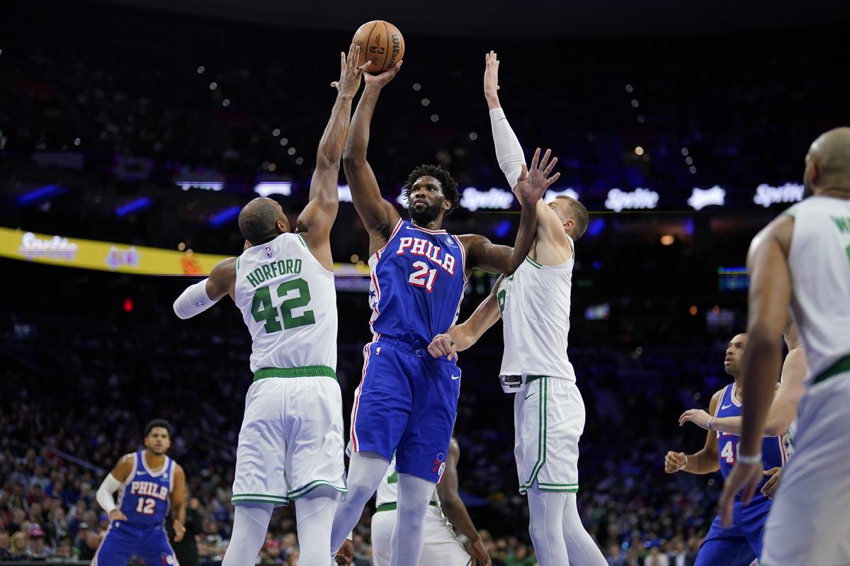 Philadelphia 76ers’ Joel Embiid, center, goes up for a shot against Boston Celtics’ Kristaps Porzingis, right, and Al Horford during the first half of an NBA basketball game.