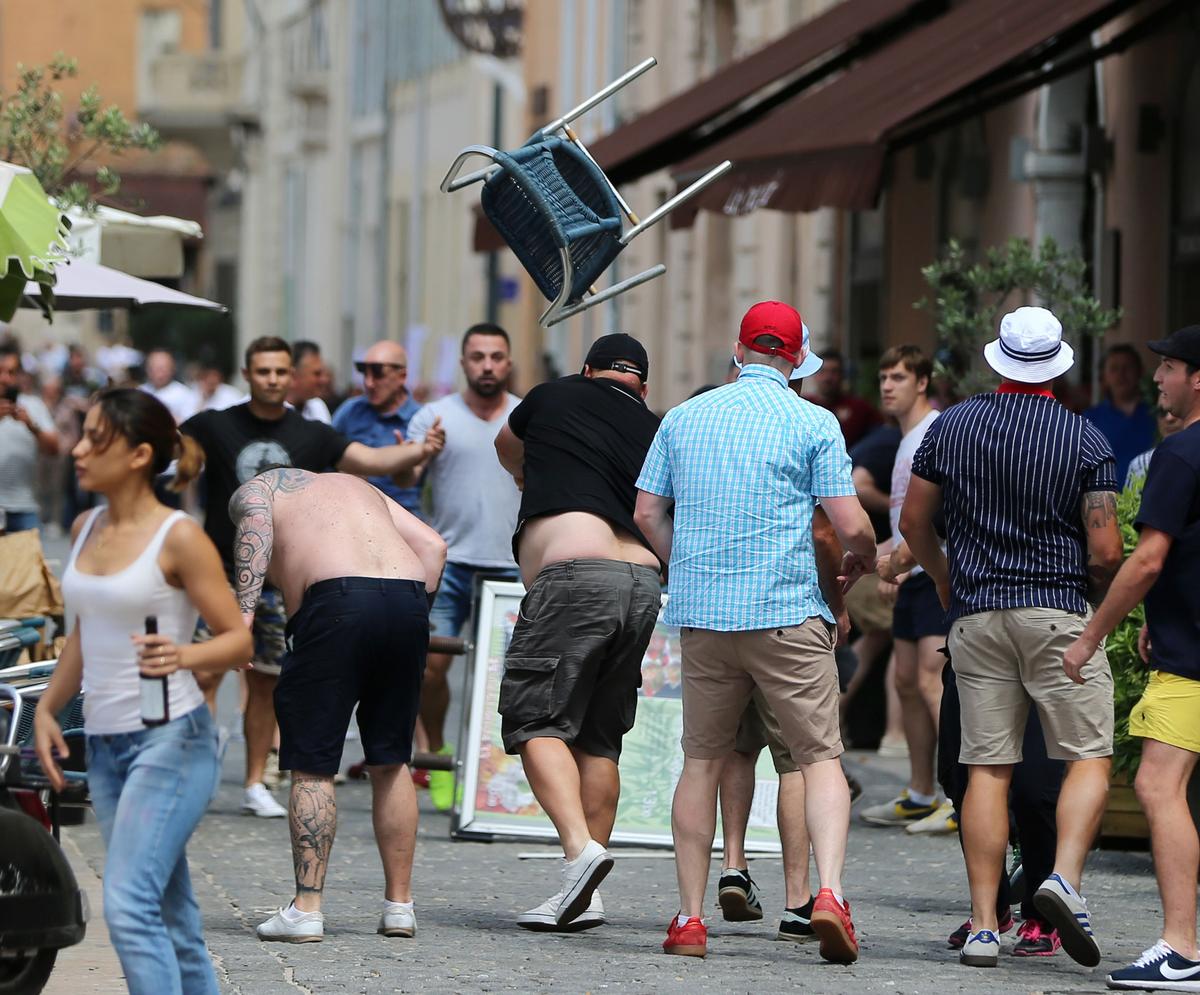 FILE PHOTO: A man throws chair as minor skirmishes continue between soccer fans, in the streets of Marseille, France, ahead of the England vs Russia France Euro 2016 soccer match, Saturday June 11, 2016.  Riot police have thrown tear gas canisters at soccer fans Saturday in Marseille’s Old Port in a third straight day of violence in the city. 