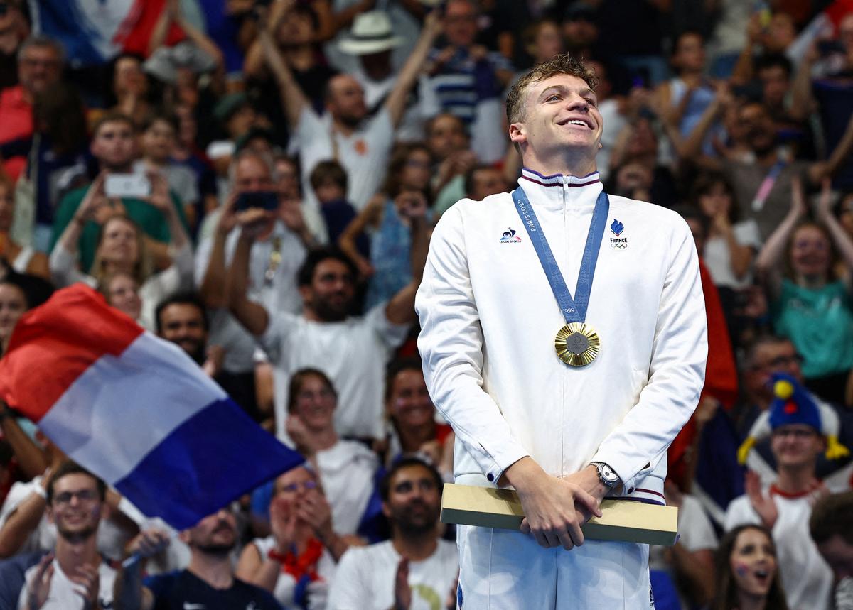 FILE PHOTO: Gold medallist Leon Marchand of France celebrates on the podium after winning and establishing Olympic record. 