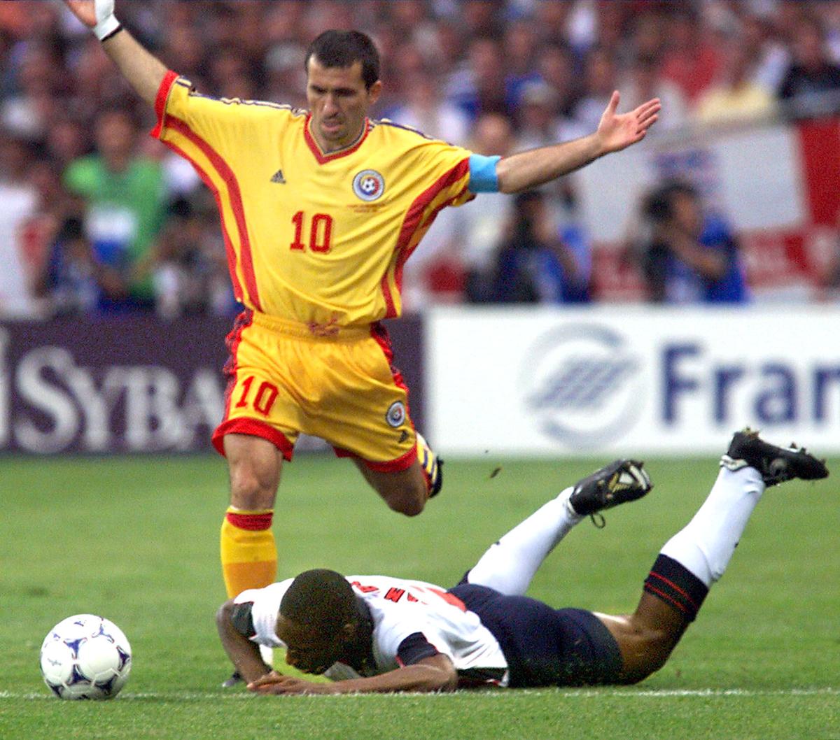 Romanian Gheorghe Hagi opens his arms as England’s Sol Campbell hits the field.