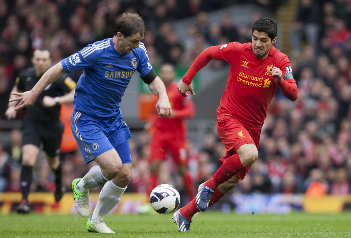 Fotografická fotografia: Liverpool's Luis Suarez bojuje za loptu proti Chelsea's Branislav Ivanovic počas zápasu anglickej Premier League na Anfield Stadium.