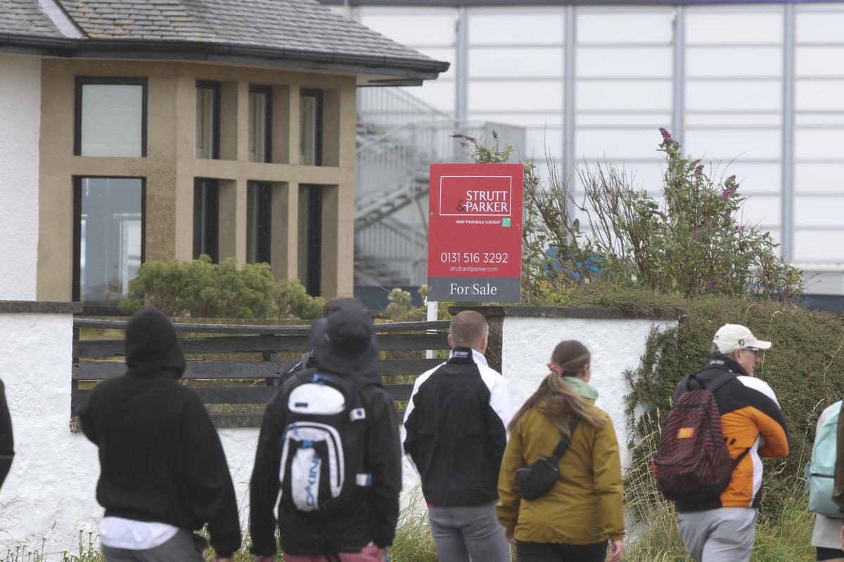 Spectators walk past “Blackrock house” that is listed for sale near the second and 16th holes at Royal Troon golf club, venue for the British Open Golf Championships, in Troon, Scotland, on Tuesday.