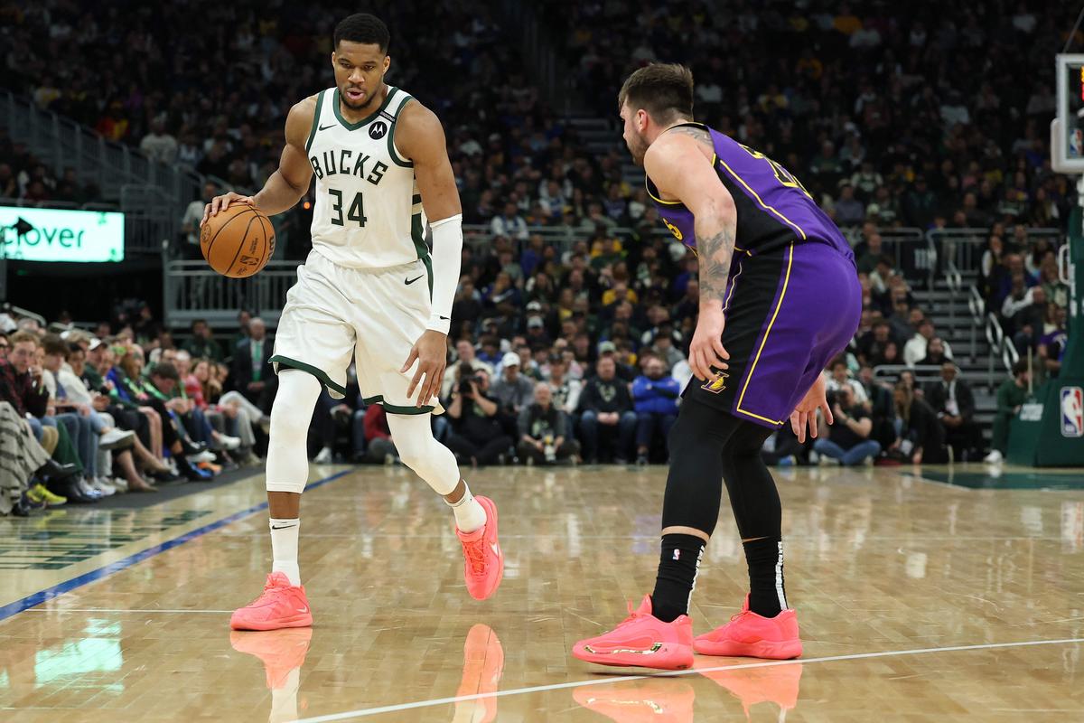 Giannis Antetokounmpo #34 of the Milwaukee Bucks is defended by Luka Doncic #77 of the Los Angeles Lakers during the first half of an NBA game at Fiserv Forum,