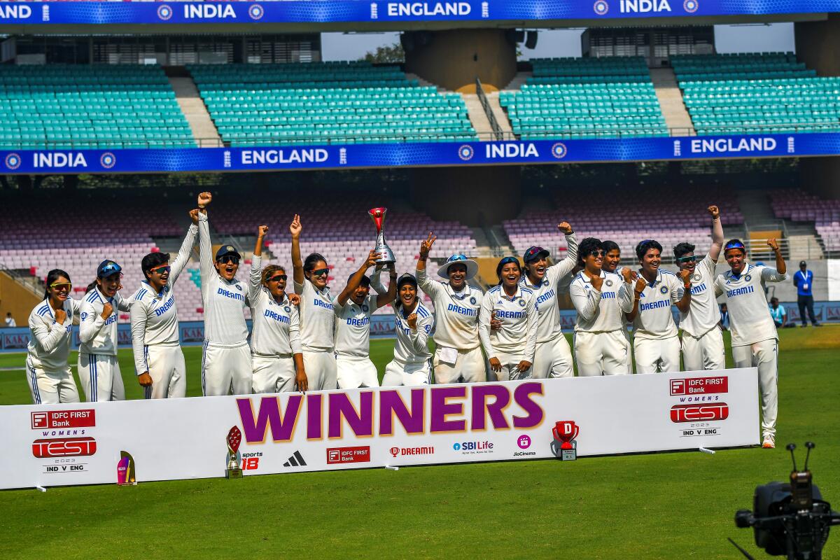 Indian women’s team celebrates with the trophy after beating England in the one-off Test at the D.Y. Patil Stadium in Navi Mumbai on Saturday.