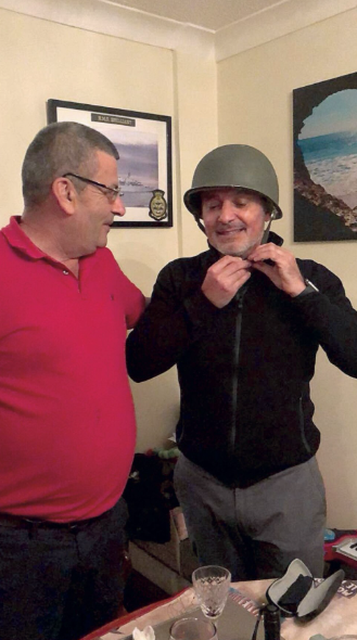 Edward Goodall (left) returning Alejandro Gorzelany his combat helmet. 