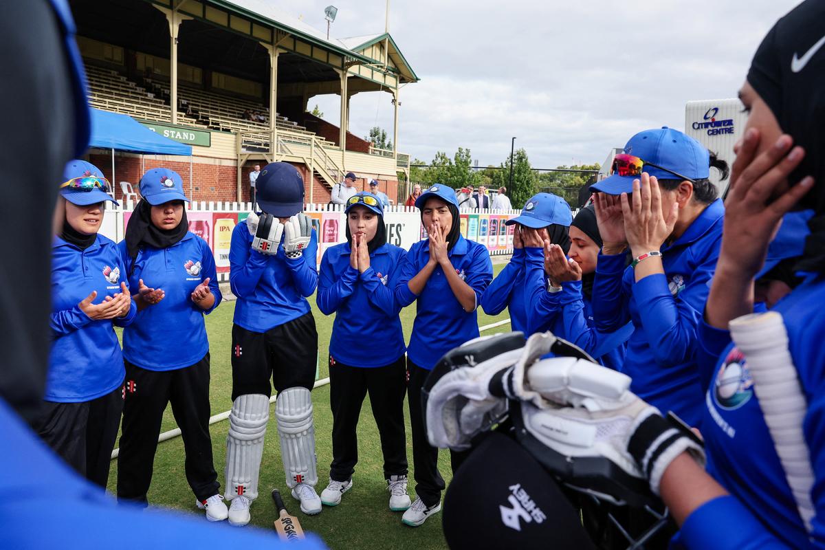 Afghanistan Women’s XI players say a prayer before the charity match against Cricket Without Borders XI at Junction Oval in Melbourne on January 30, 2025. 