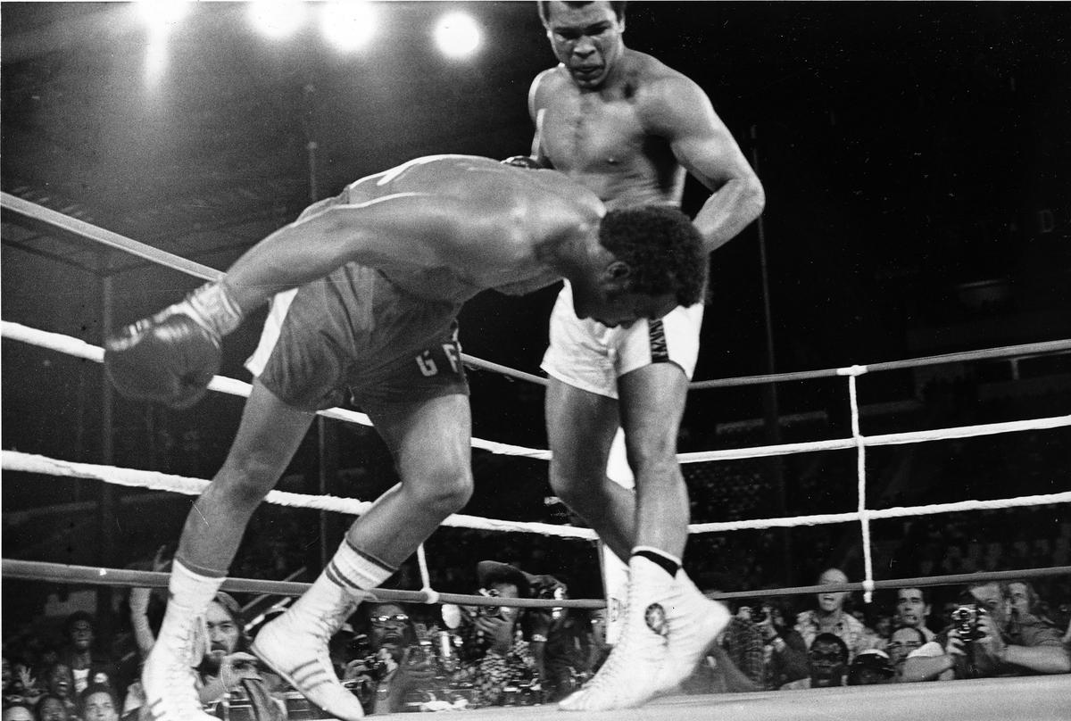 FILE PHOTO: Muhammad Ali (right) watches as defending world champion George Foreman (left) goes down to the canvas in the eighth round of their WBA/WBC championship match, on Oct. 30, 1974, in Kinshasa, Zaire. 