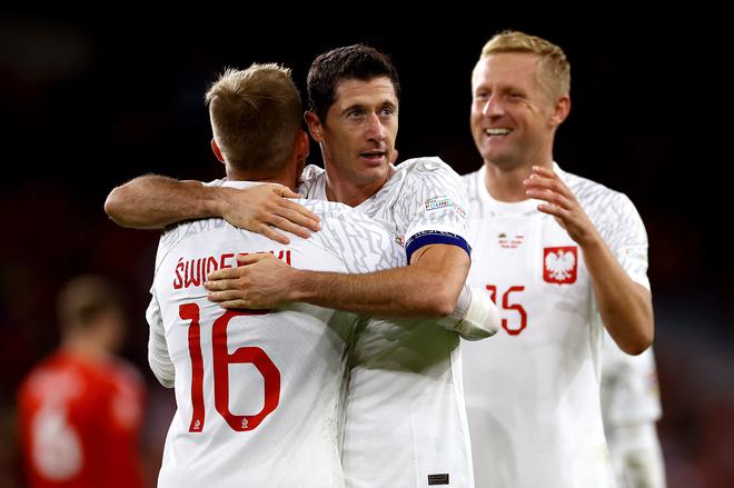 Karol Swiderski of Poland celebrates with teammate Robert Lewandowski after scoring their team’s first goal during the UEFA Nations League League A Group 4 match between Wales and Poland at Cardiff City Stadium on September 25, 2022, in Cardiff, Wales.