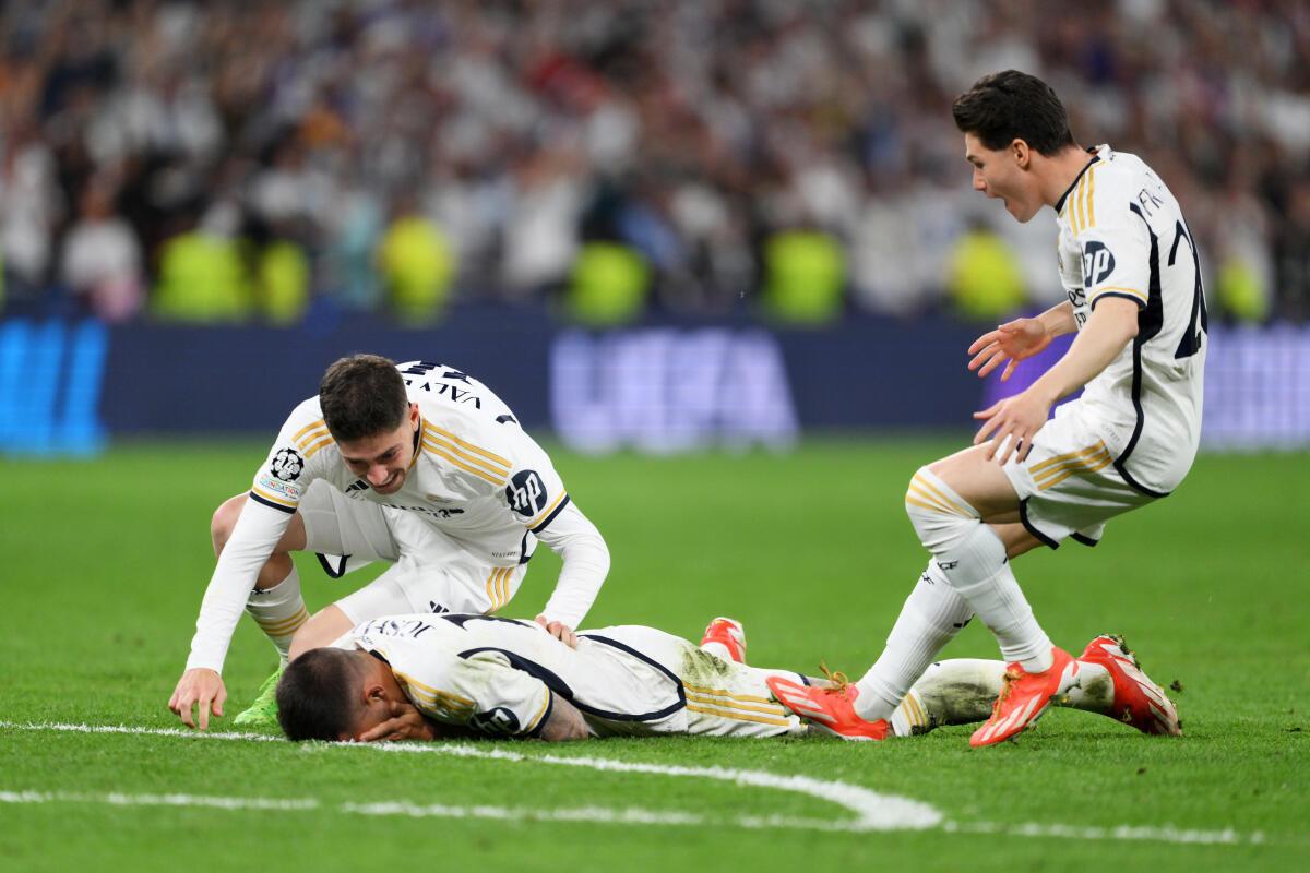 Real Madrid players engulf Joselu after the team’s win over Bayern Munich.