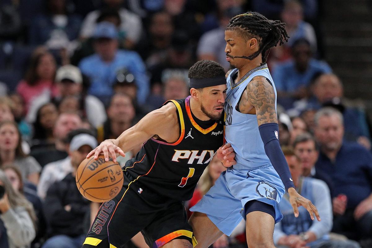 Devin Booker #1 of the Phoenix Suns handles the ball against Ja Morant #12 of the Memphis Grizzlies during the second half at FedExForum on March 10. 