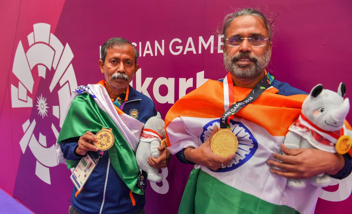 Bridge players Pranab Bardhan (R) and Shibnath De Sarkar with their gold medals at the 18th Asian Games.