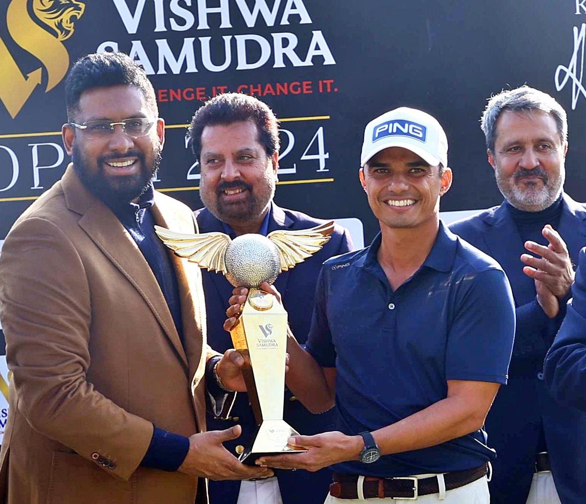 Champion Ajeetesh Sandhu receives trophy from Shivdutt Das in the Vishwa Samudra golf championship in Delhi on Friday, watched by Uttam Singh Mundy and Amandeep Singh Johl.