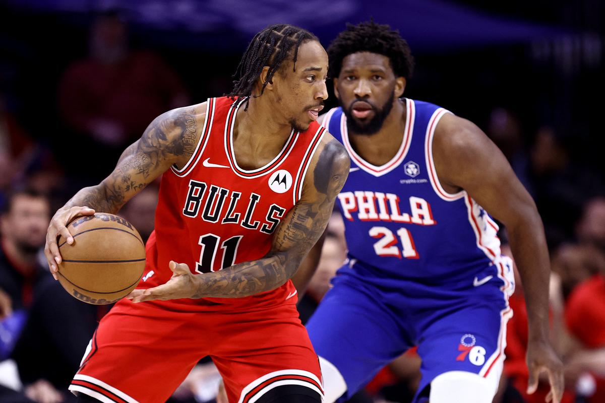 DeMar DeRozan #11 of the Chicago Bulls is guarded by Joel Embiid #21 of the Philadelphia 76ers during the third quarter at the Wells Fargo Center on December 18, 2023 in Philadelphia, Pennsylvania.