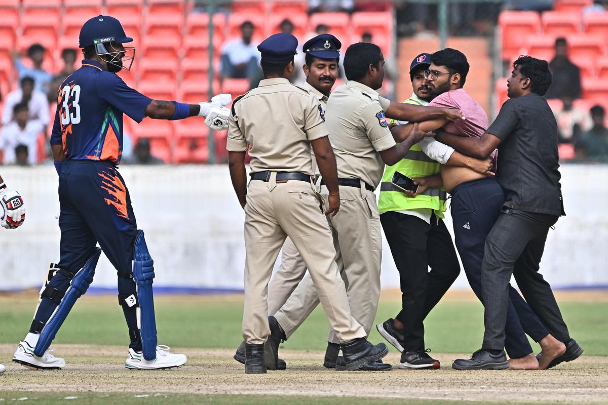 Hardik Pandya intervenes as security escorts a fan away during the clash between Baroda and Punjab.