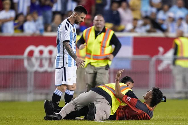 A fan is tackled as he tries to take a picture of Argentina’s player Lionel Messi during the second half of an international friendly match against Jamaica on Tuesday, Sept. 27, 2022, in Harrison, N.J. 