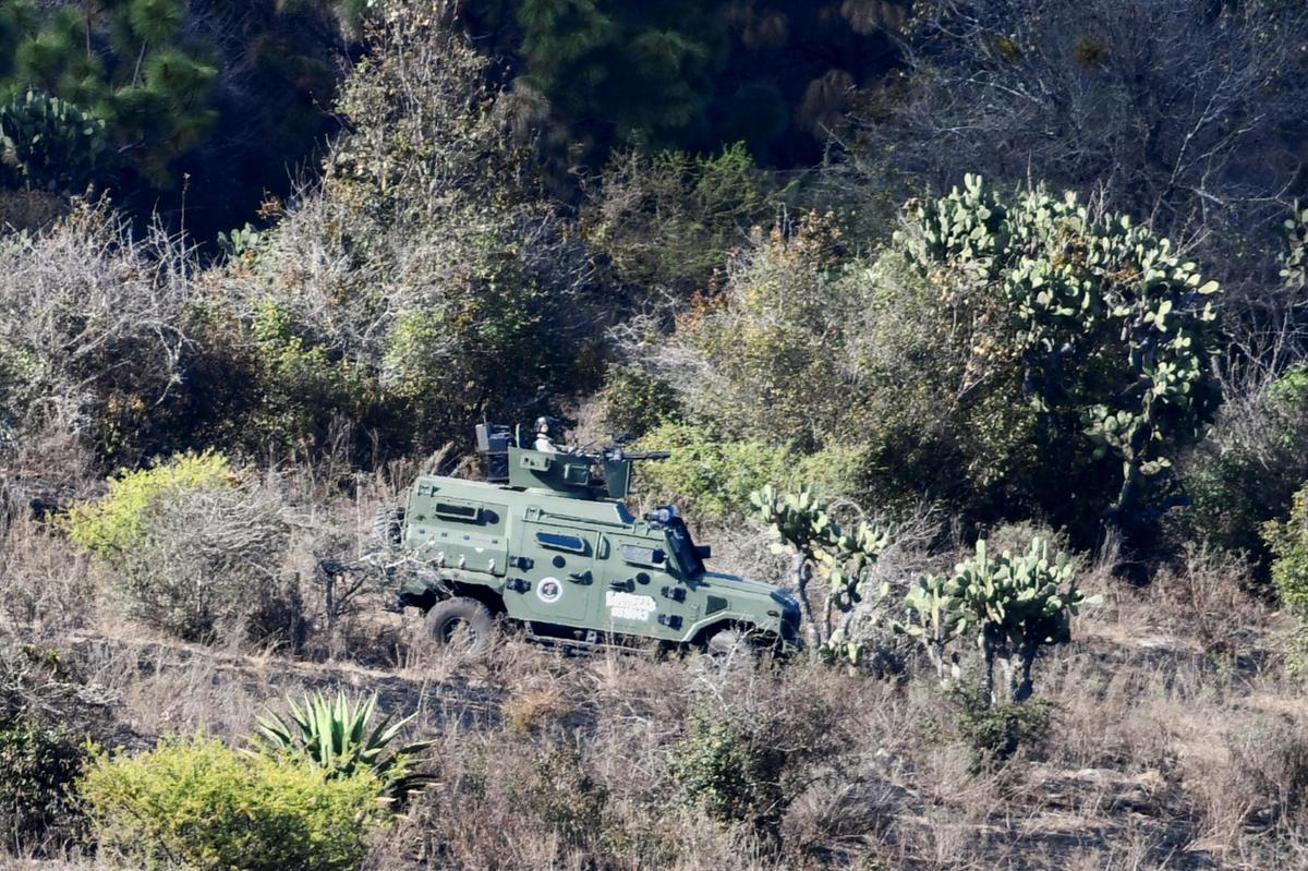 Soldados perto de técnicos forenses (não retratados) que trabalhavam no local onde as forças federais conduziam uma operação para capturar El Mencho, que morreu em um helicóptero após ser ferido durante um ataque das forças especiais mexicanas.
