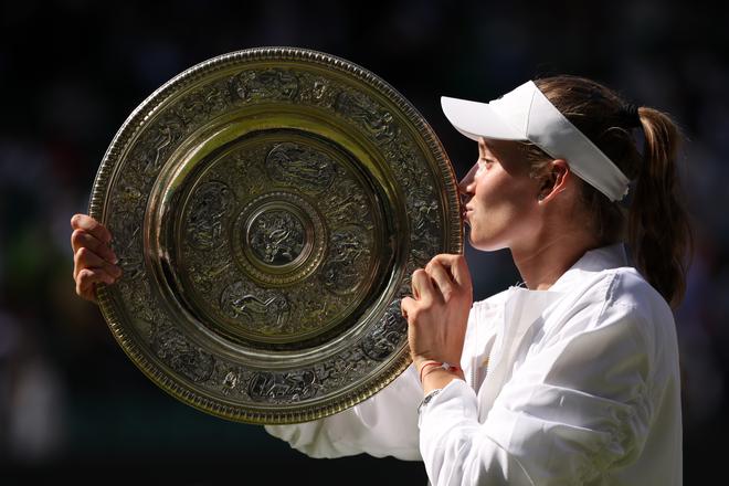 Elena Rybakina of Kazakhstan kisses the trophy after victory against Ons Jabeur of Tunisia during the Ladies’ Singles Final match on day thirteen of The Championships Wimbledon 2022.