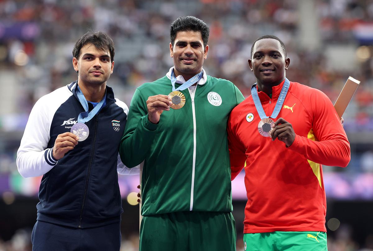 Javelin throw gold medalist Pakistan’s Arshad Nadeem (C), silver medalist India’s Neeraj Chopra (L) and bronze medallist Grenada’s Anderson Peters (R) celebrate on the podium. 