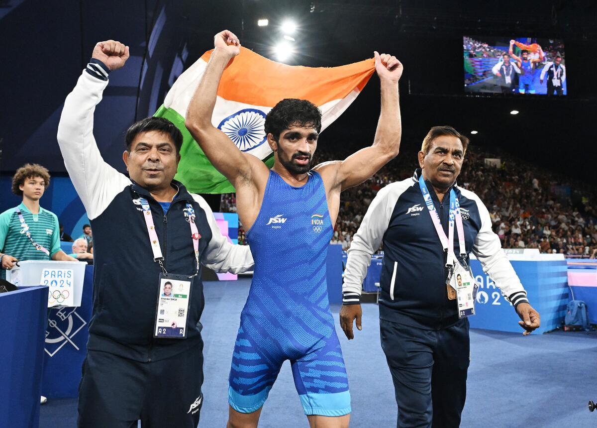 Aman celebrates after winning bronze in the men’s freestyle 57kg match against Darian Toi Cruz of Puerto Rico in Champ-de-Mars Arena in Paris.  