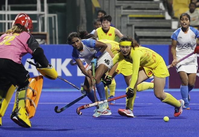 India’s Vandana Katariya, center, passes the ball against China’s Yu Zhou during their women’s hockey match at the 18th Asian Games in Jakarta, Indonesia.