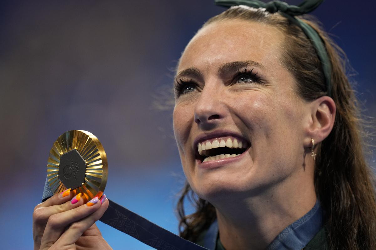 Tatjana Smith, of South Africa, poses with her gold medal after winning the women’s 100-meter breaststroke final at the 2024 Summer Olympics.