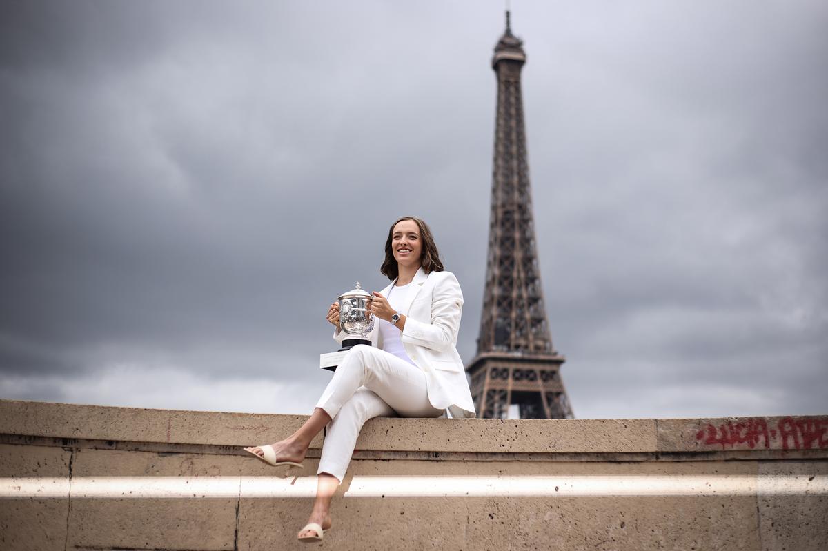 Iga Swiatek poses with the French Open trophy.