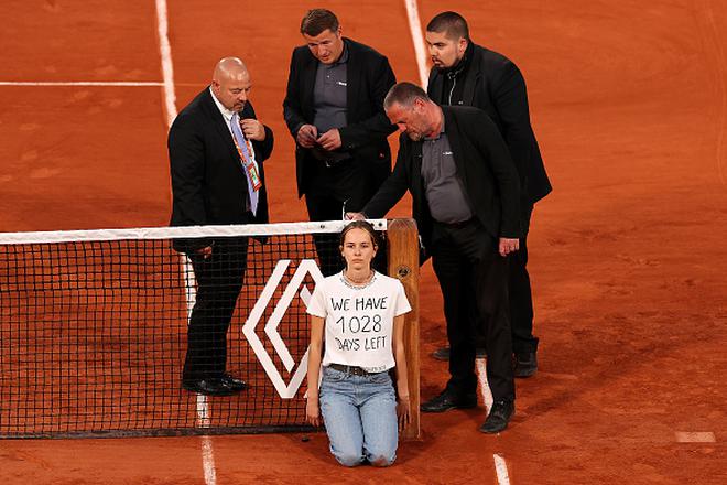 A protester ties herself to the net during the men’s singles semifinal match of the French Open between Marin Cilic and Casper Ruud at Roland Garros on June 03, 2022 in Paris, France. 