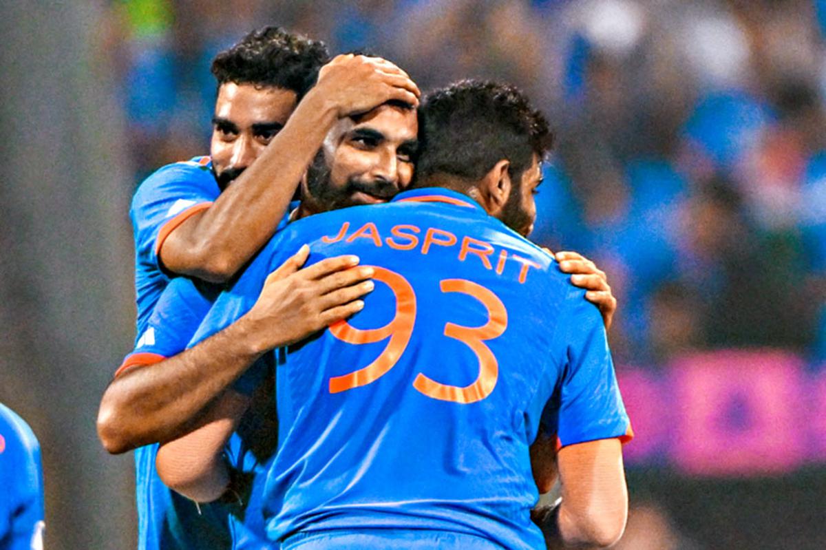 Mohammed Shami, Mohammed Siraj and Jaspreet Bumrah celebrate during a World Cup match. 