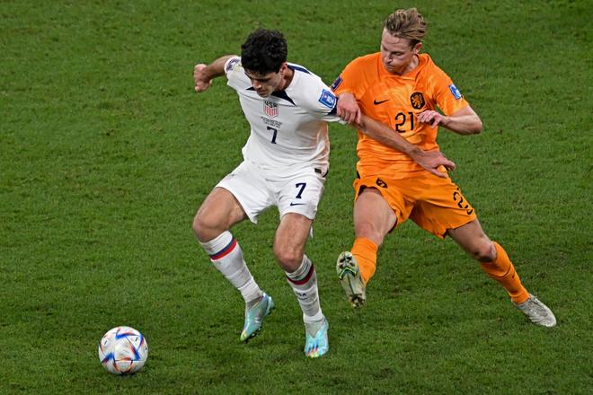USA’s Giovanni Reyna (L) and Netherlands’ Frenkie De Jong fight for the ball during the Qatar 2022 World Cup round of 16 football match between the Netherlands and USA at Khalifa International Stadium in Doha on December 3, 2022.