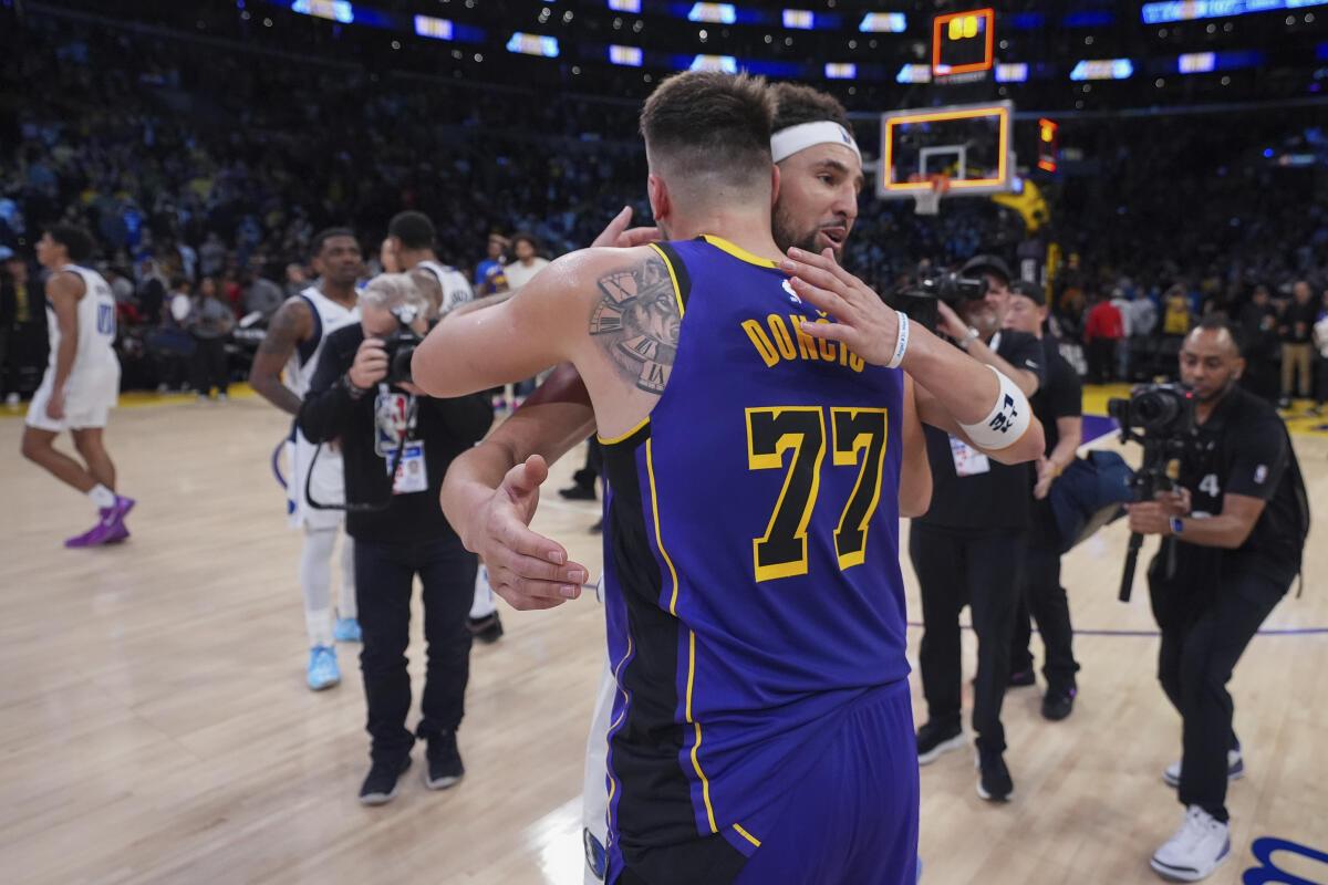 Los Angeles Lakers guard Luka Doncic (77) and Dallas Mavericks guard Klay Thompson (31) hug after an NBA basketball game. 