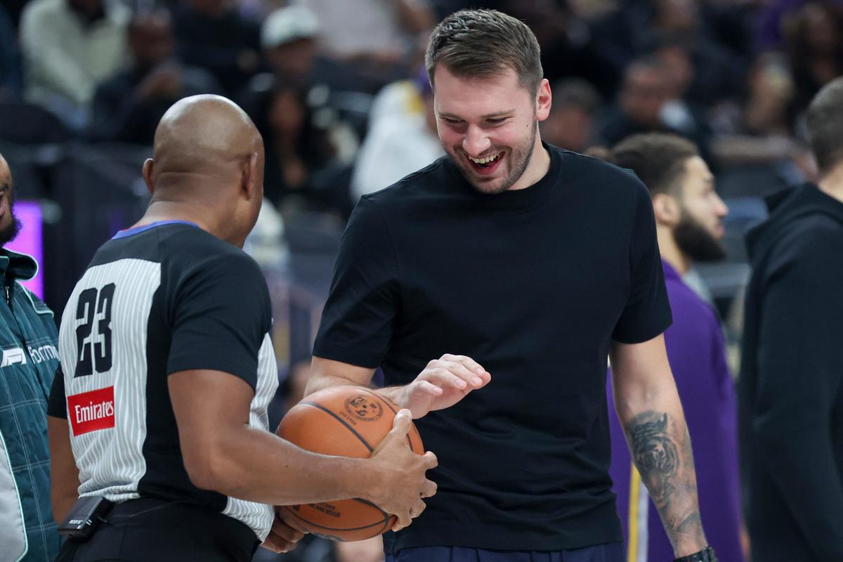 Los Angeles Lakers’ Luka Doncic, right, talks to referee Tre Maddox (23) during the first half of a preseason NBA game.