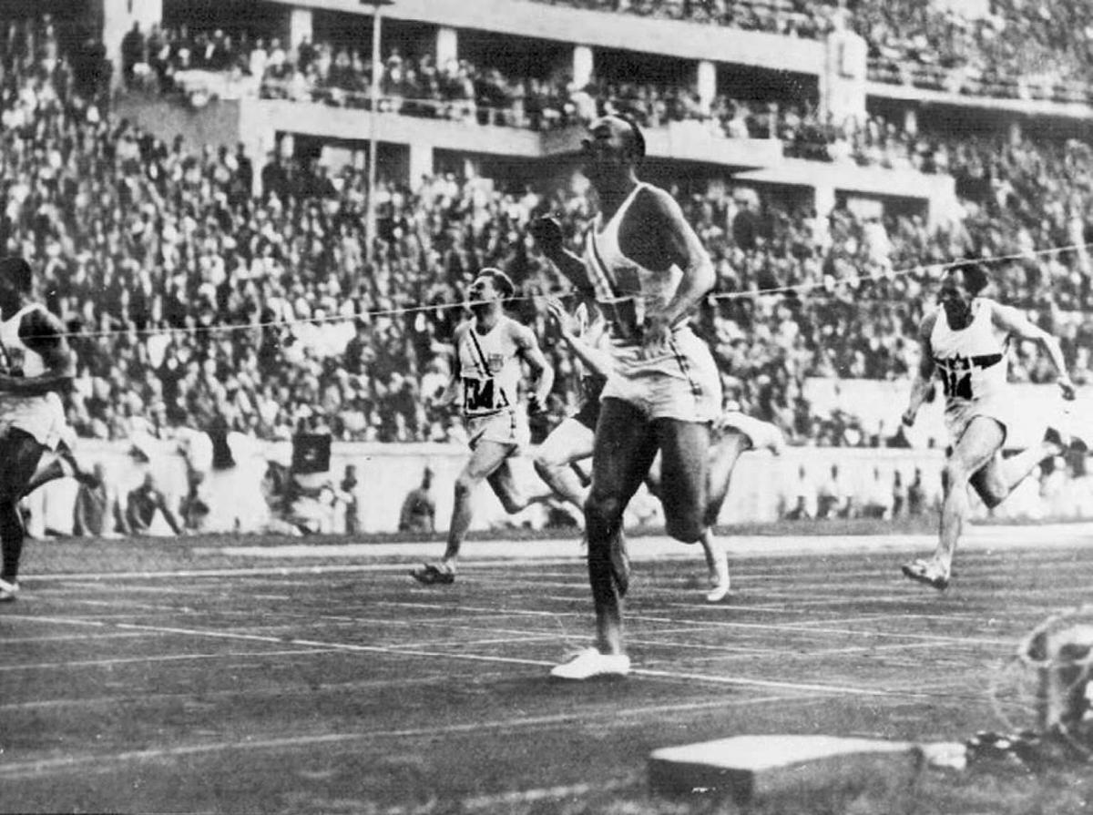 US athlete Jesse Owens crossing the finish line to win the 100 meter and setting a new world record at the Berlin Olympics in 1936.